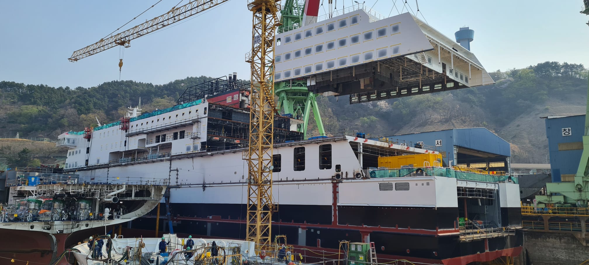 Ferry in shipyard being built with cranes around it