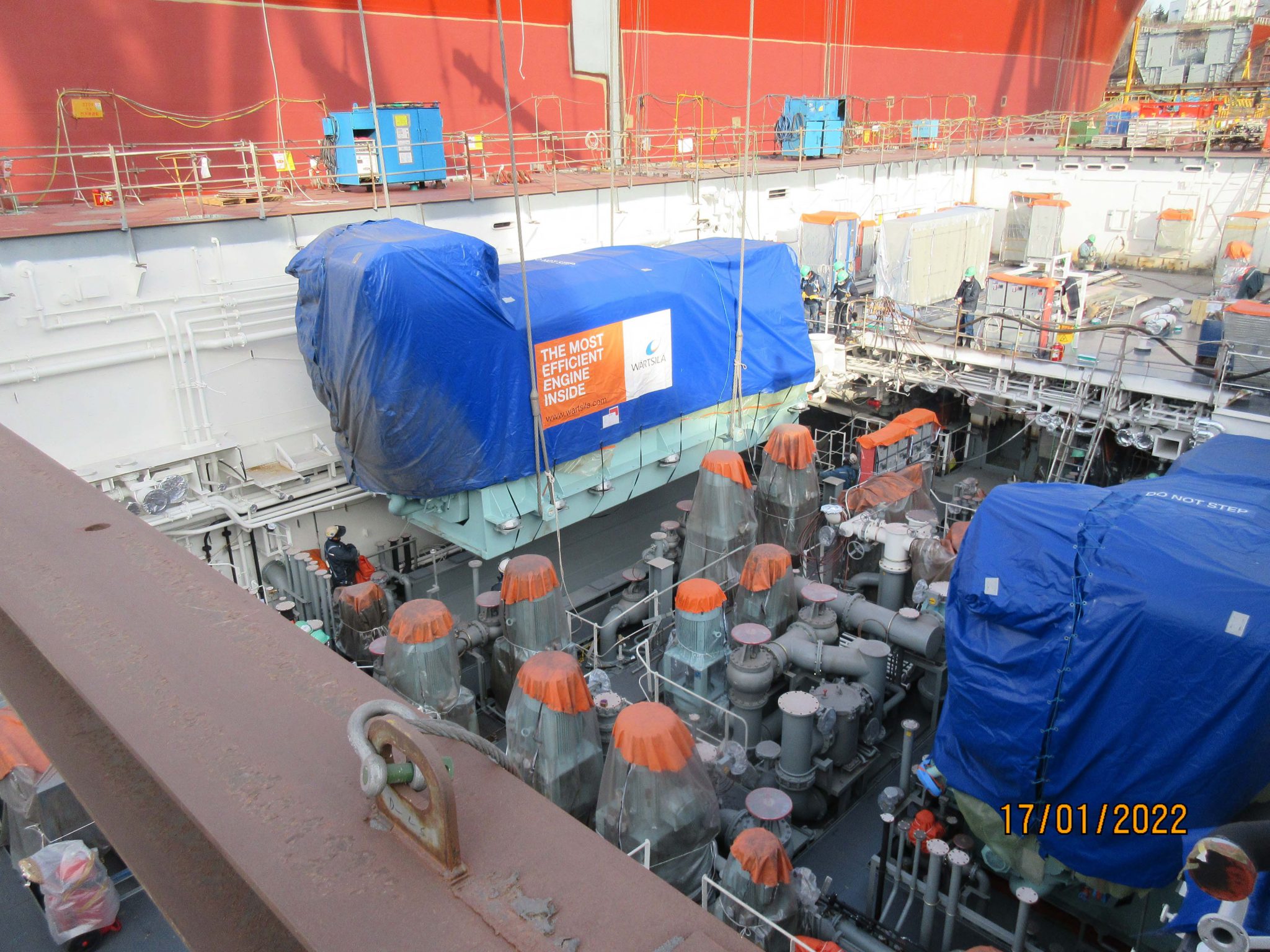 Engine room mid-build of a ferry with engines being lowered in in the shipping yard