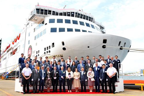 People standing in front of a ferry to celebrate the official launch of the ferry