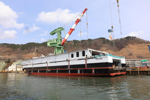 Ferry in shipyard being built with cranes around it in the sea