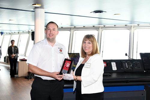 Captain of ferry receiving plaque from a lady