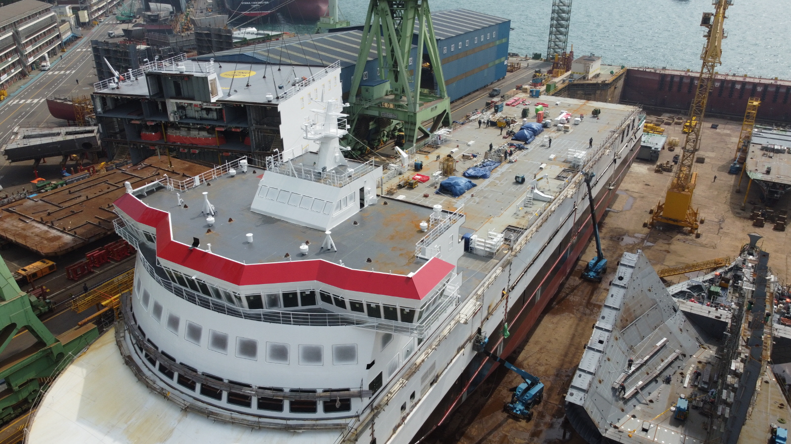 Ferry in shipyard being built with cranes around it