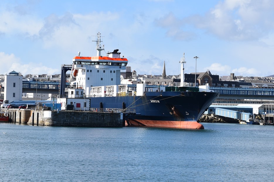 View from sea looking at the MV Arrow ferry docked at harbour on a sunny day